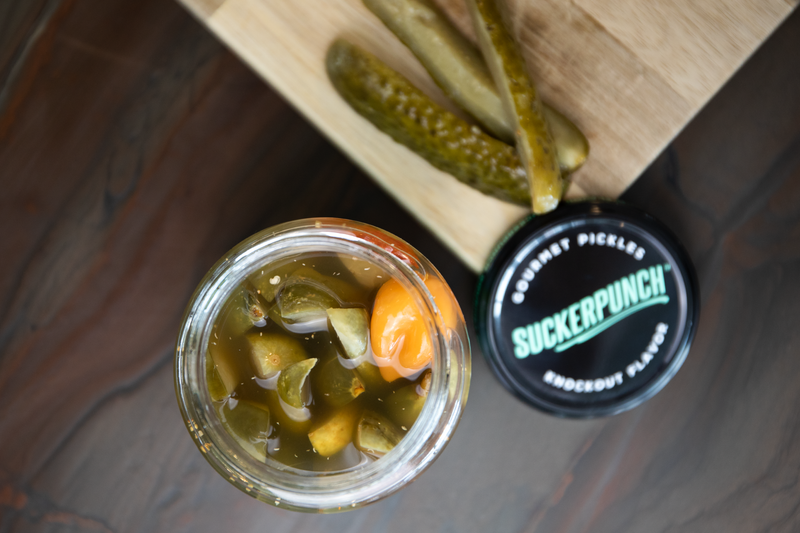 Woman's hand taking pickles from the jar