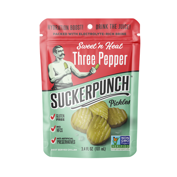 A 3.4 fl oz pouch of Sweet 'n Heat Three Pepper Suckerpunch Pickles, featuring a red and mint green design with an illustration of a man holding a pickle and photos of whole pickles on the front.